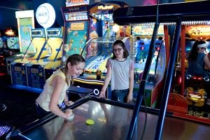 Guests playing air hockey in arcade
