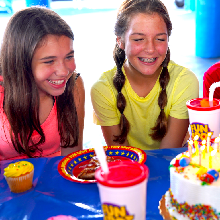 Two kids smiling around birthday cake at Fun Spot